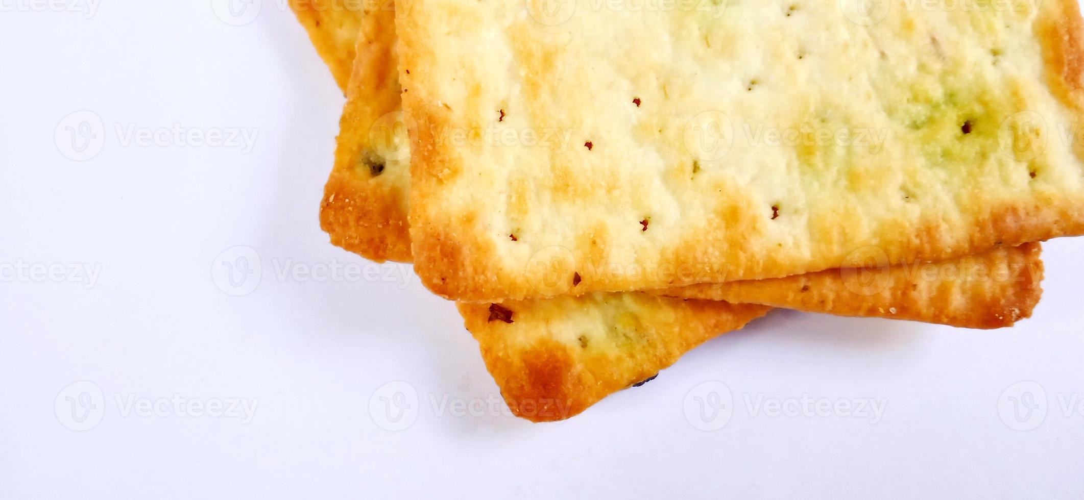 Sugarless and vegetable healthy cracker biscuit slices on the gray white studio background. Food background design. Suitable for promotion of food and beverage industry and company, food advertising. photo