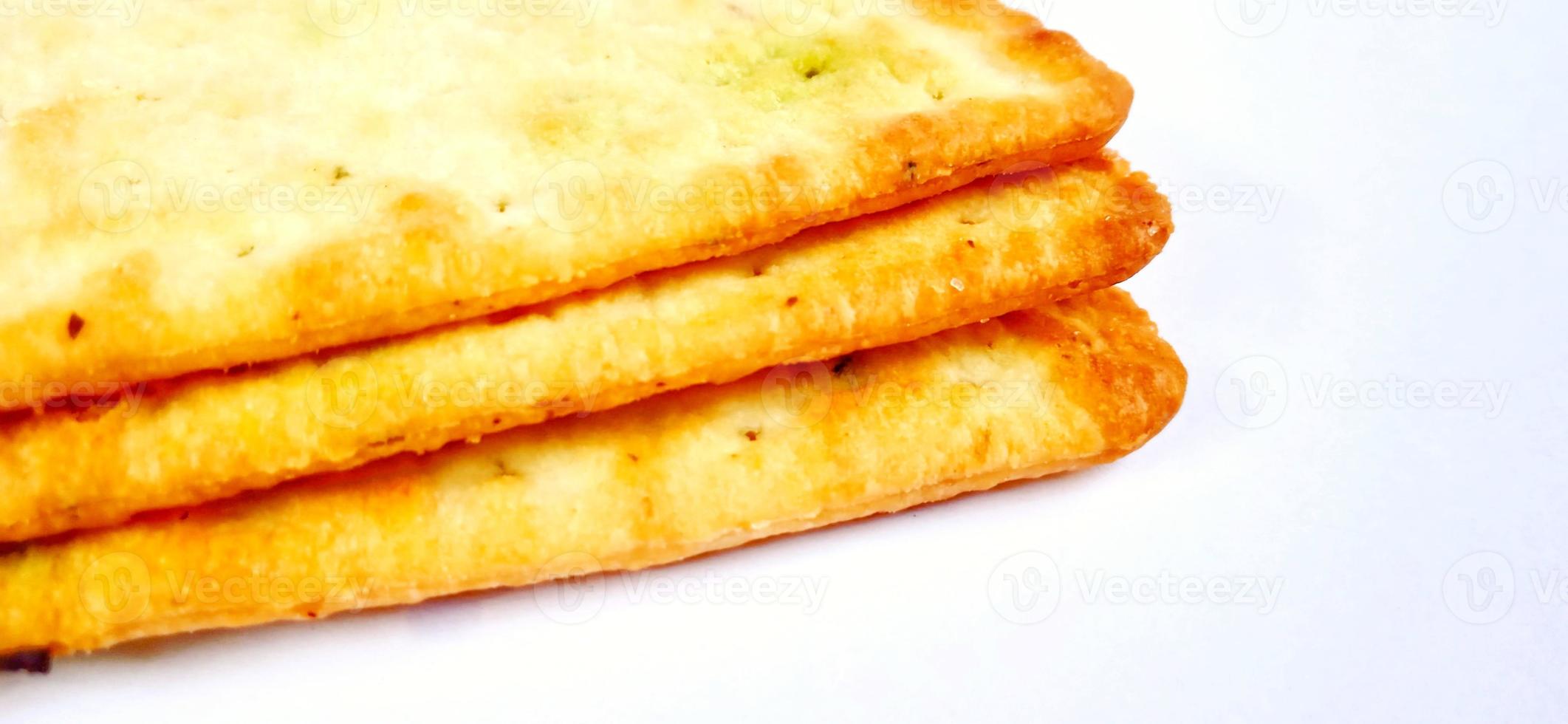 Sugarless and vegetable healthy cracker biscuit slices on the gray white studio background. Food background design. Suitable for promotion of food and beverage industry and company, food advertising. photo