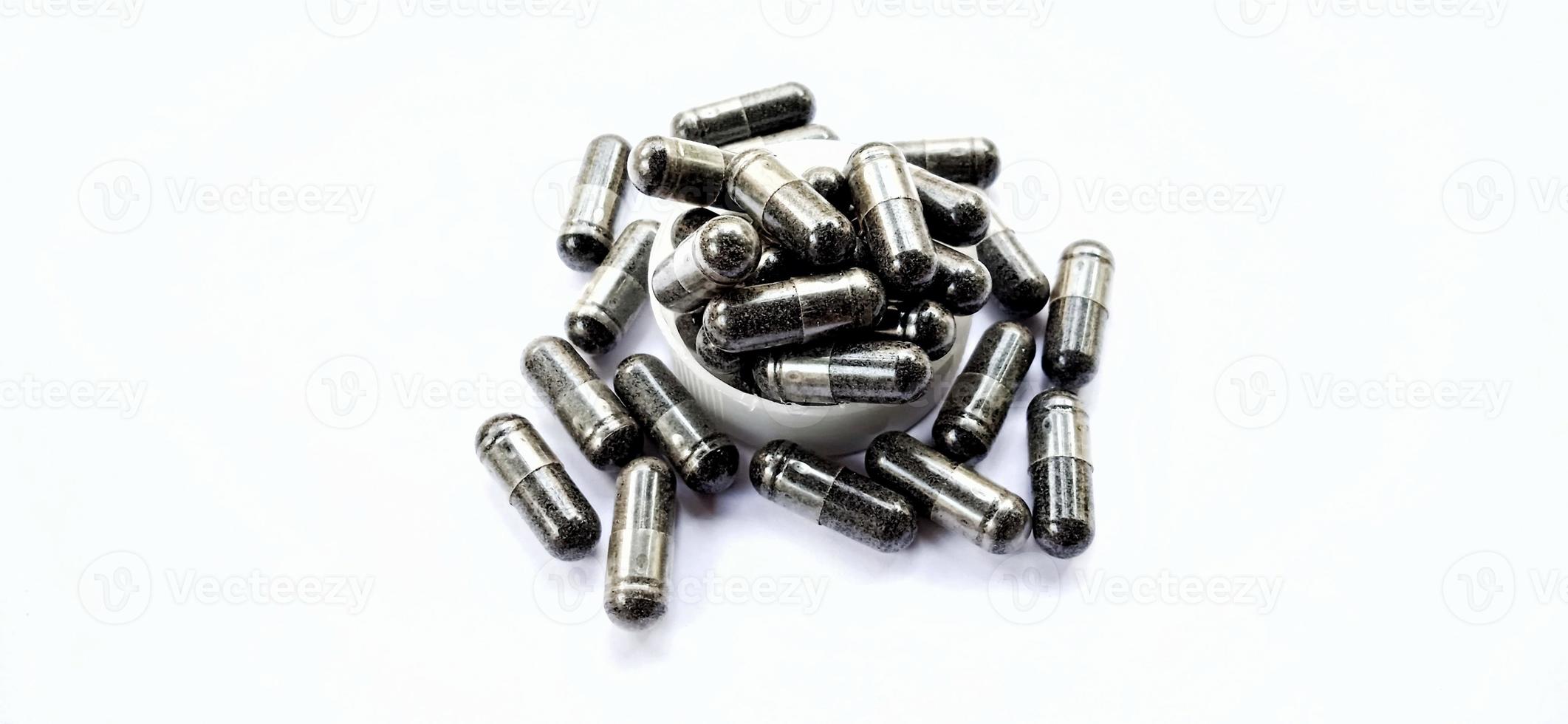 Herbal medicine black cumin capsules with negative space isolated on the gray white studio background. Nigella sativa. Suitable for promotion of health industry and company. photo