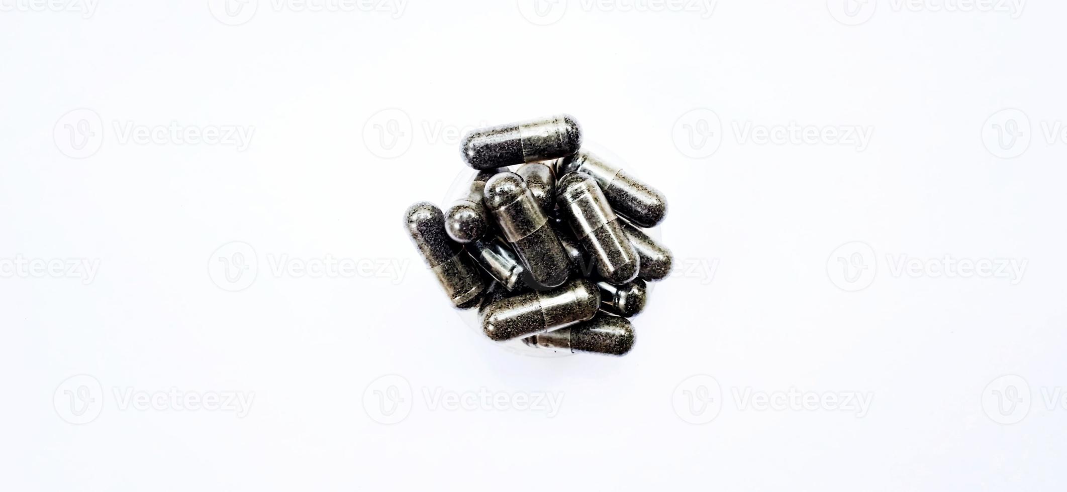 Herbal medicine black cumin capsules with negative space isolated on the gray white studio background. Nigella sativa. Suitable for promotion of health industry and company. photo