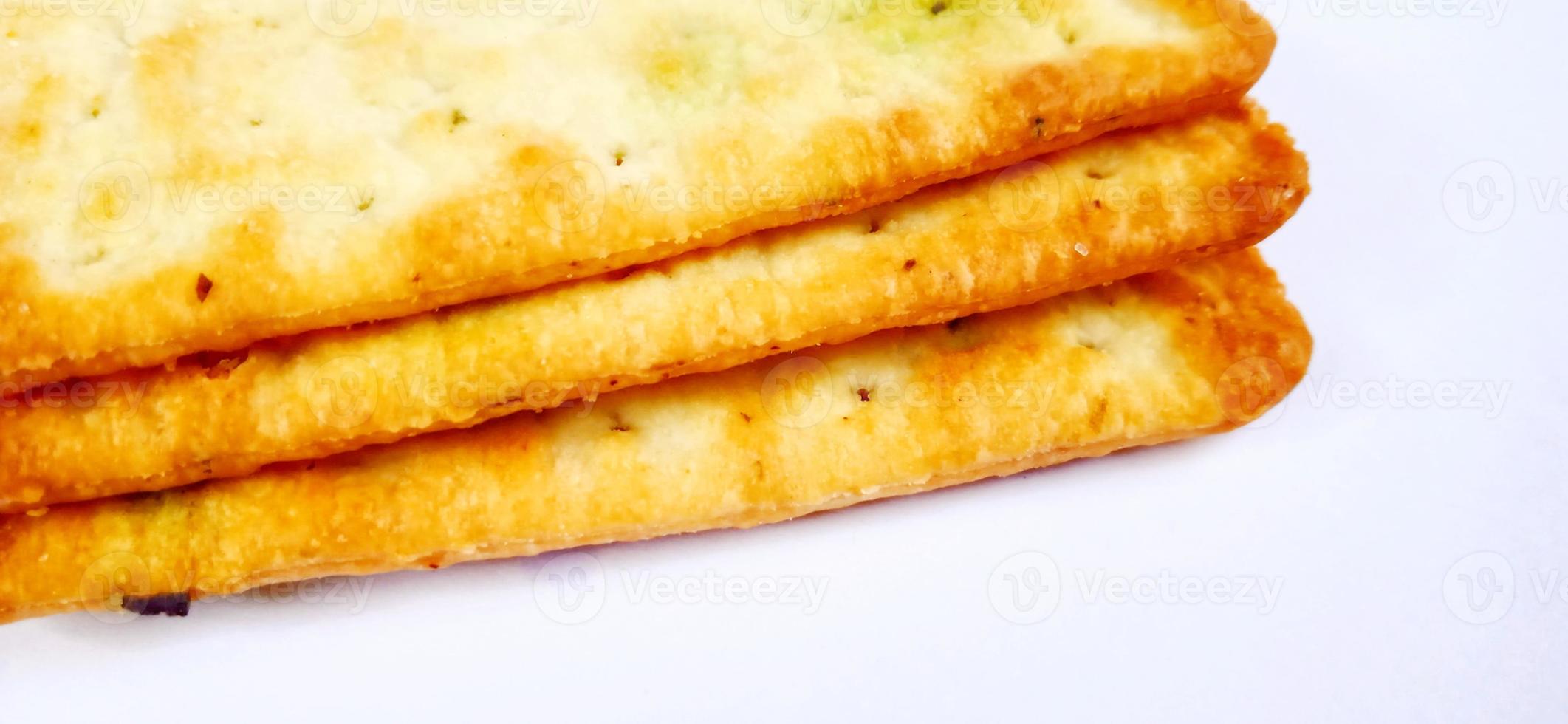 Sugarless and vegetable healthy cracker biscuit slices on the gray white studio background. Food background design. Suitable for promotion of food and beverage industry and company, food advertising. photo