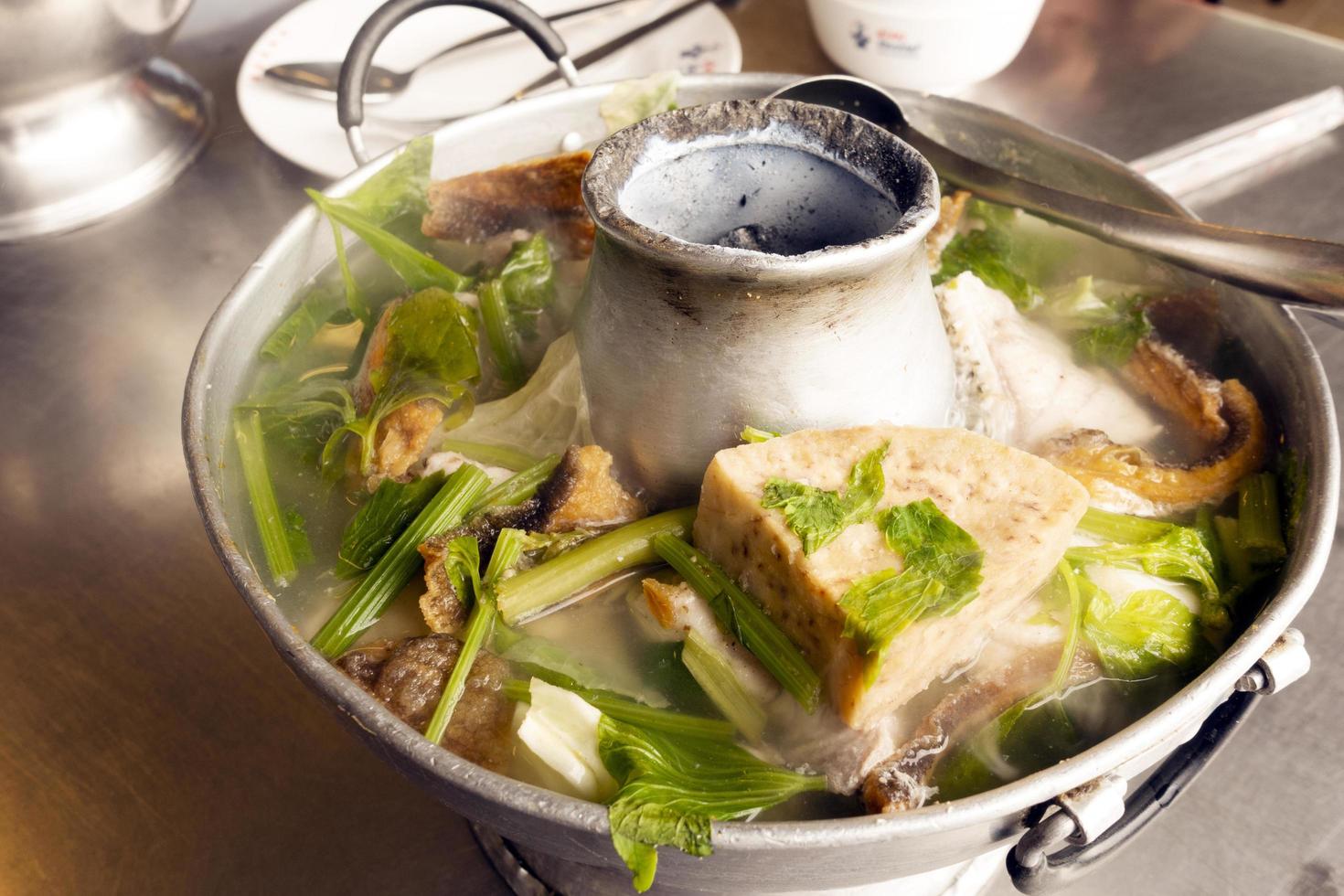 sopa de pescado con taro en una olla caliente foto