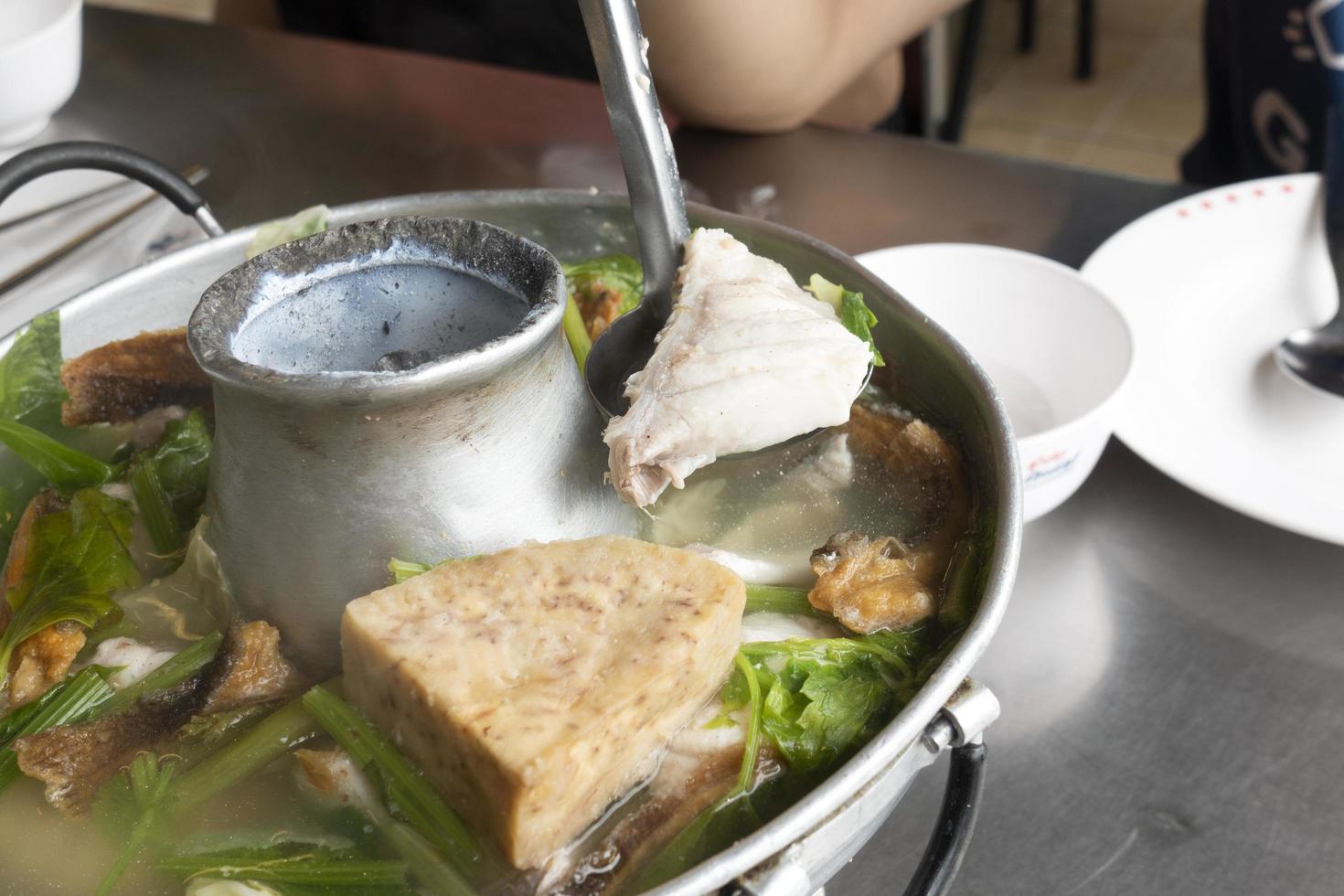 sopa de pescado con taro en una olla caliente foto