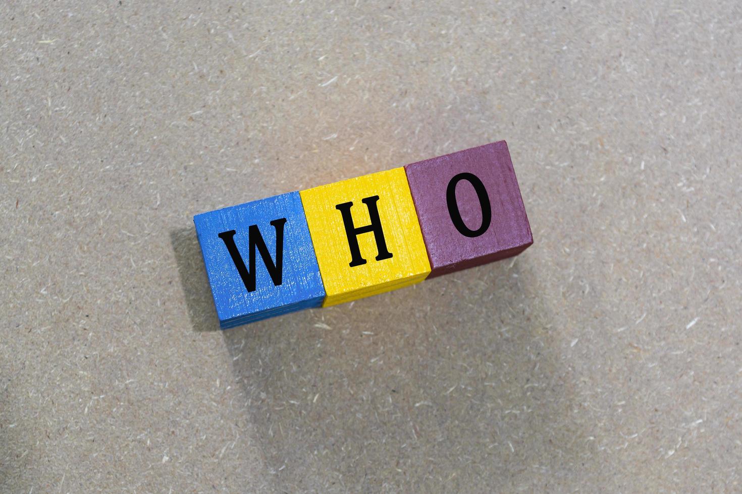 WHO acronym on colorful wooden cubes against wooden background. photo