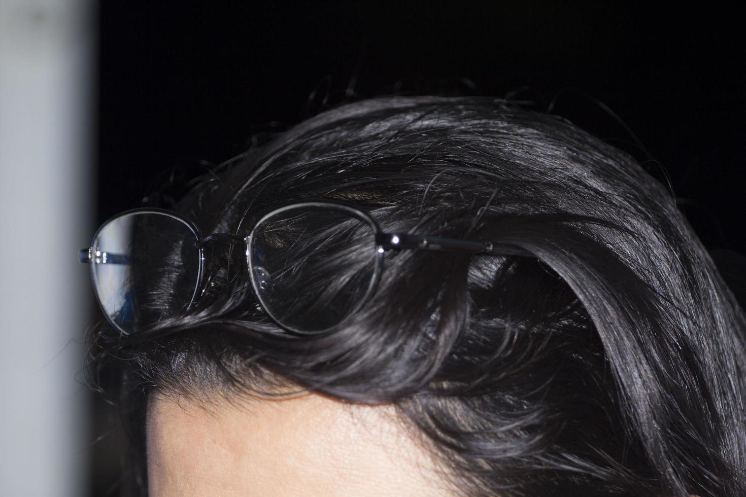Eyeglasses - wrapped on a girl's head on top of her head - in the noble night resting - with a shadow reflecting through the eyeglasses - short-term. photo