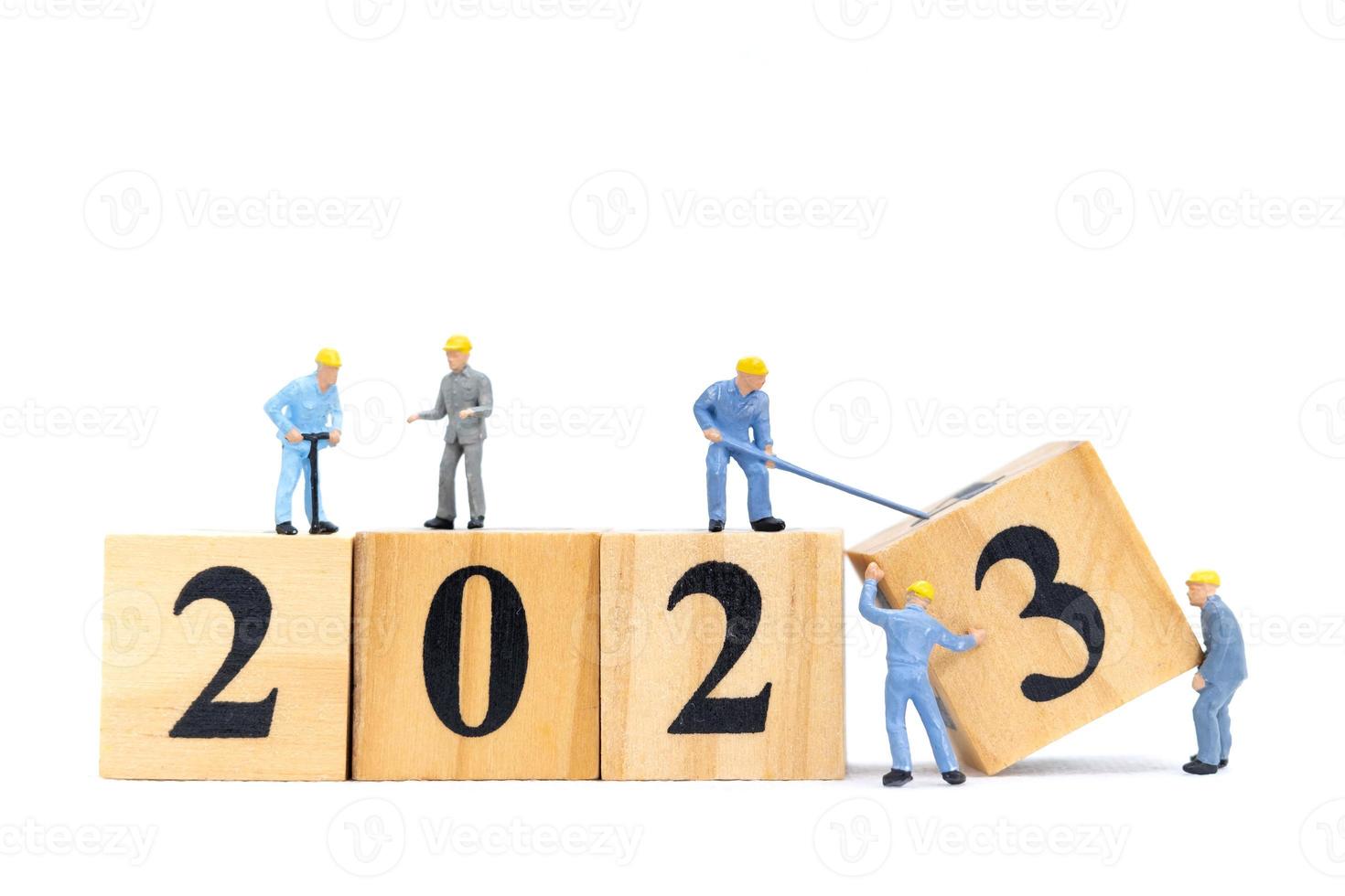 Miniature People Worker Team Create Number 2023 On Wooden Block photo