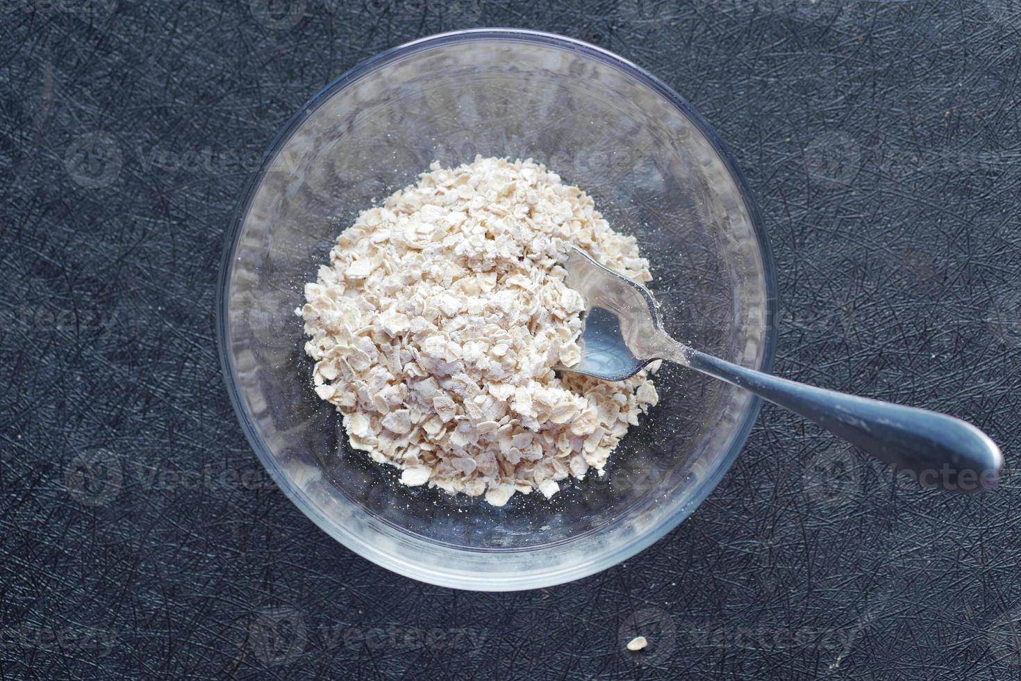 Close up of oats flakes in a glass bowl on black photo