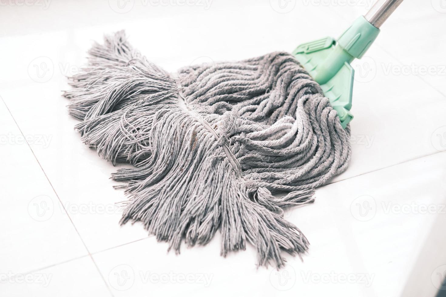 cleaning tiles floor with mop photo