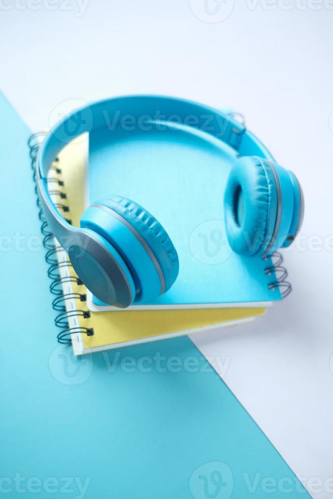 Audio book concept. Headphones and notepad on table photo