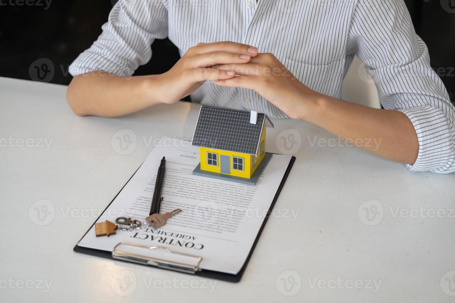 Accountant, businessman, real estate agent, business woman handing model house to customers along with house interest calculation documents for customers to sign. photo