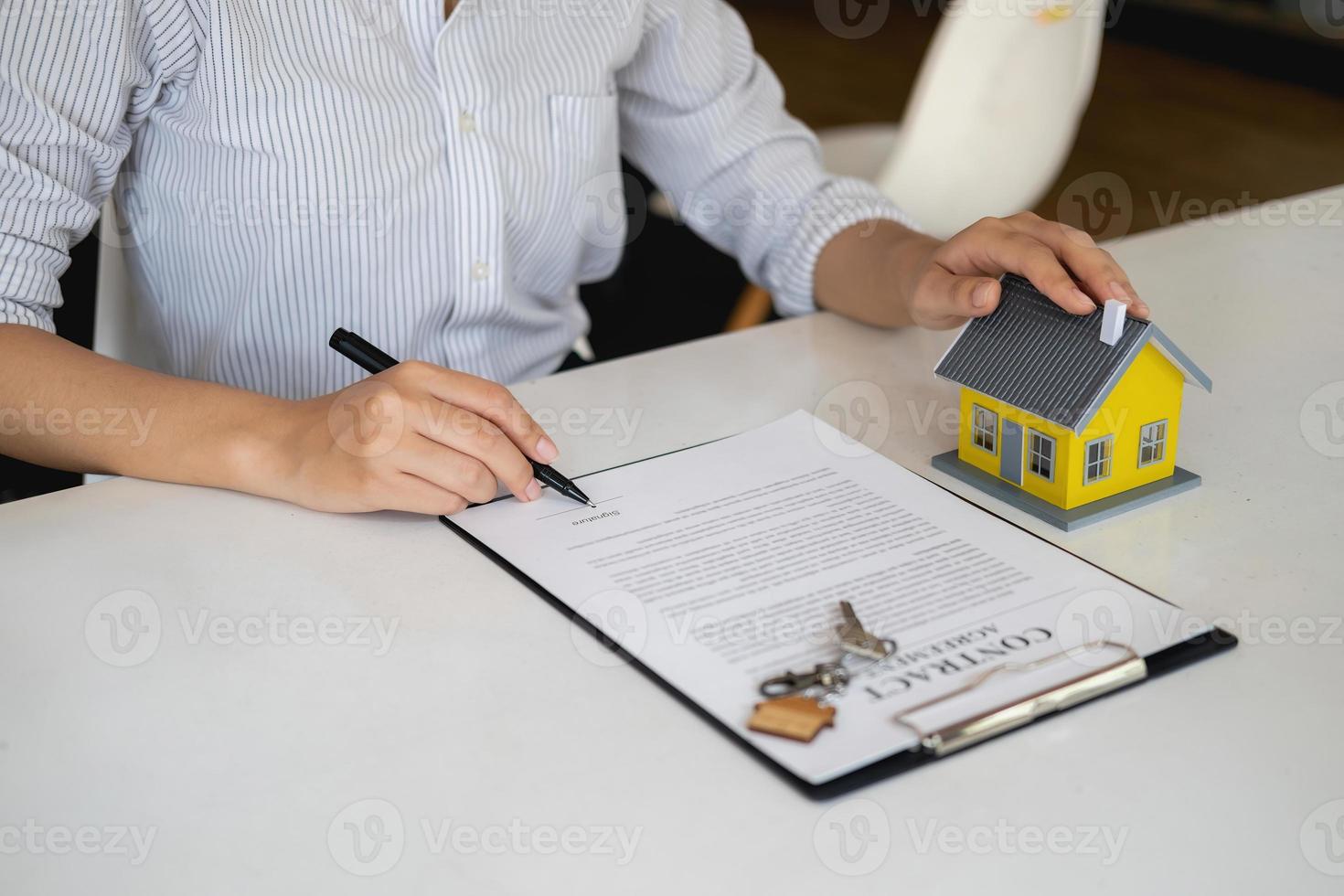 Accountant, businessman, real estate agent, business woman handing model house to customers along with house interest calculation documents for customers to sign. photo