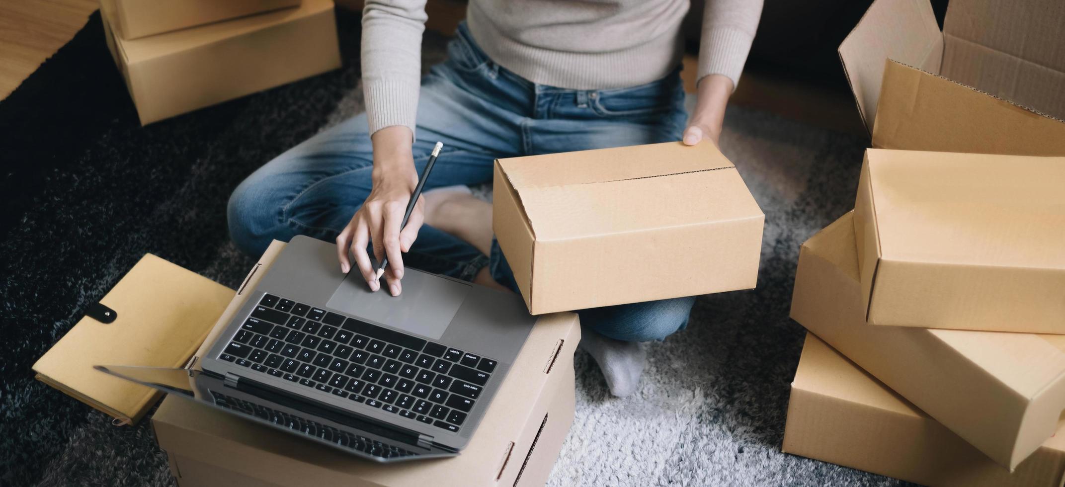 Starting small businesses SME owners female entrepreneurs Write the address on receipt box and check online orders to prepare to pack the boxes, sell to customers, sme business ideas online. photo
