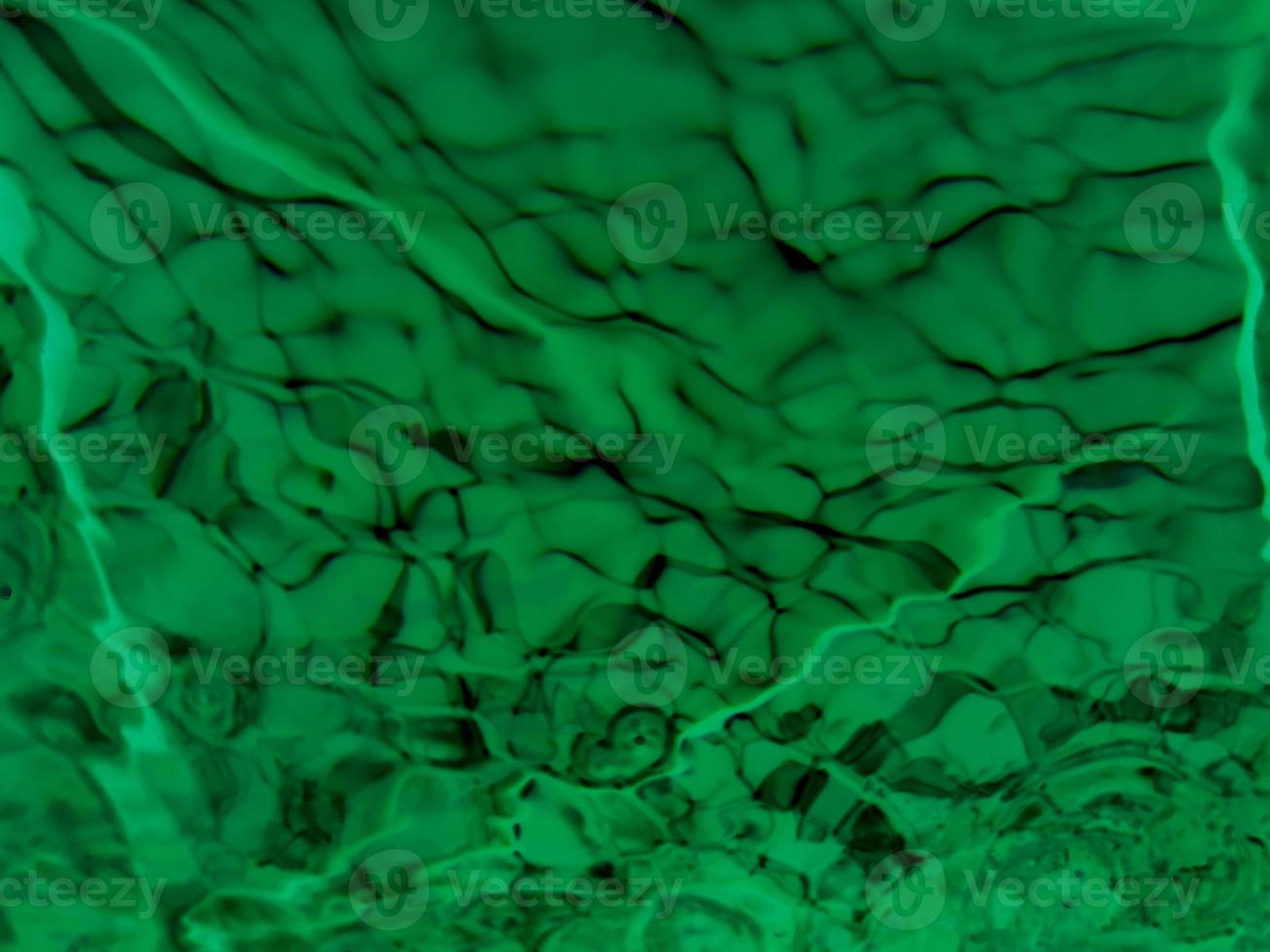 Defocus blurred transparent green colored clear calm water surface texture with splashes and bubbles. Trendy abstract nature background. Water waves in sunlight. Blue water background. photo