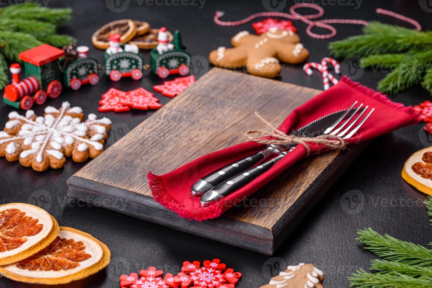 Festive Christmas table with appliances, gingerbreads, tree branches and dried citrus trees photo