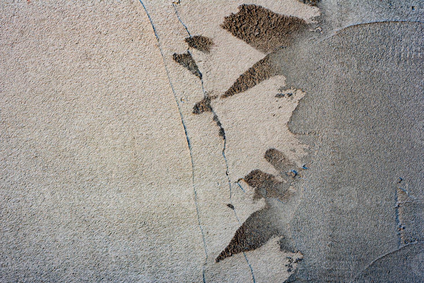 Texture of a concrete wall with cracks and scratches which can be used as a background photo