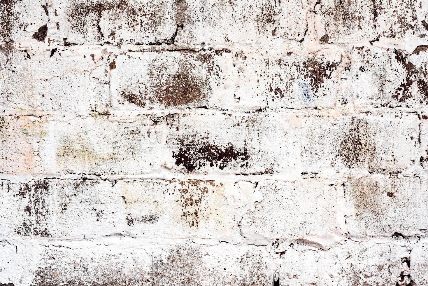 Weathered texture of stained old dark white and orange brick wall background photo