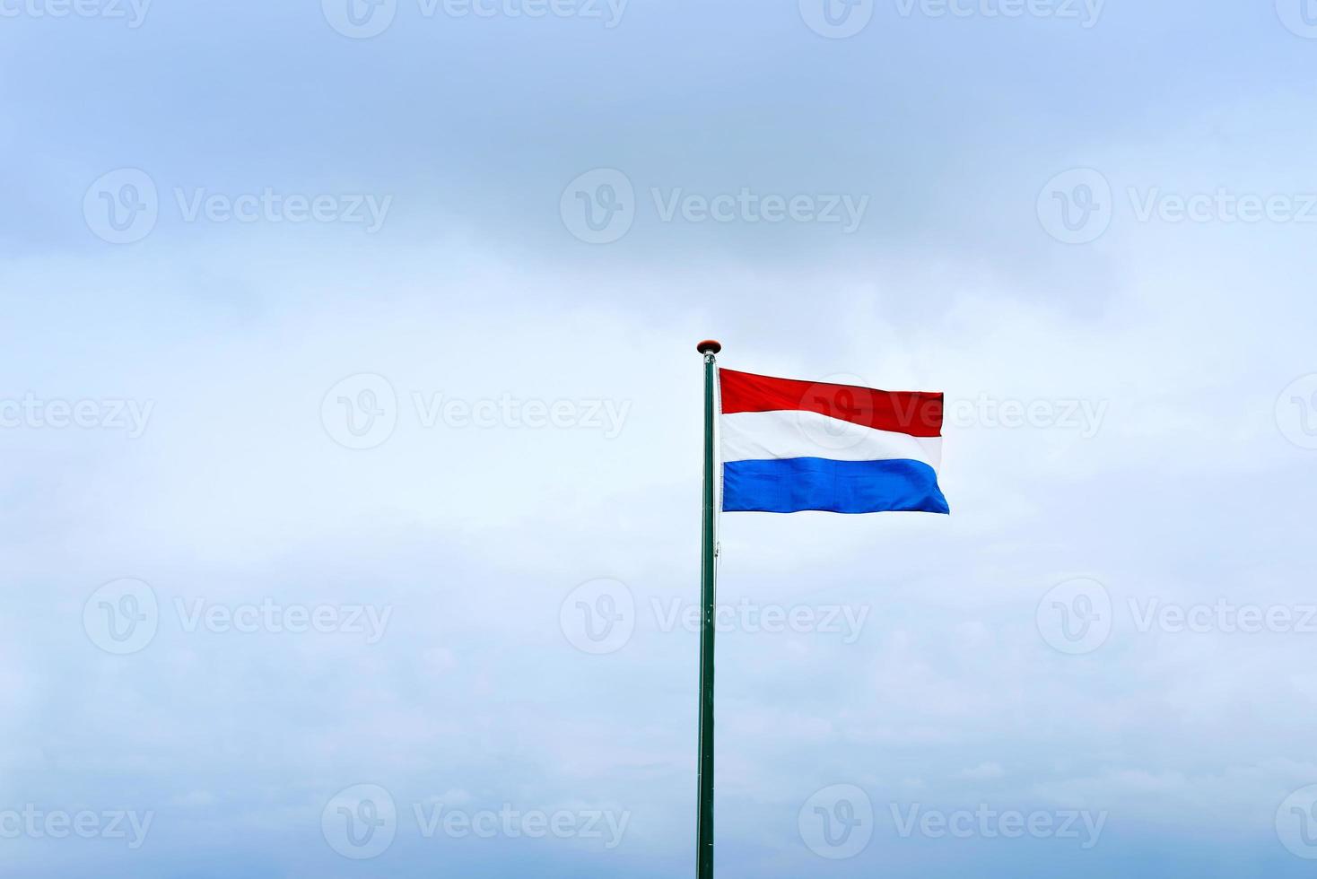 dutch flag on cloudy sky background. photo