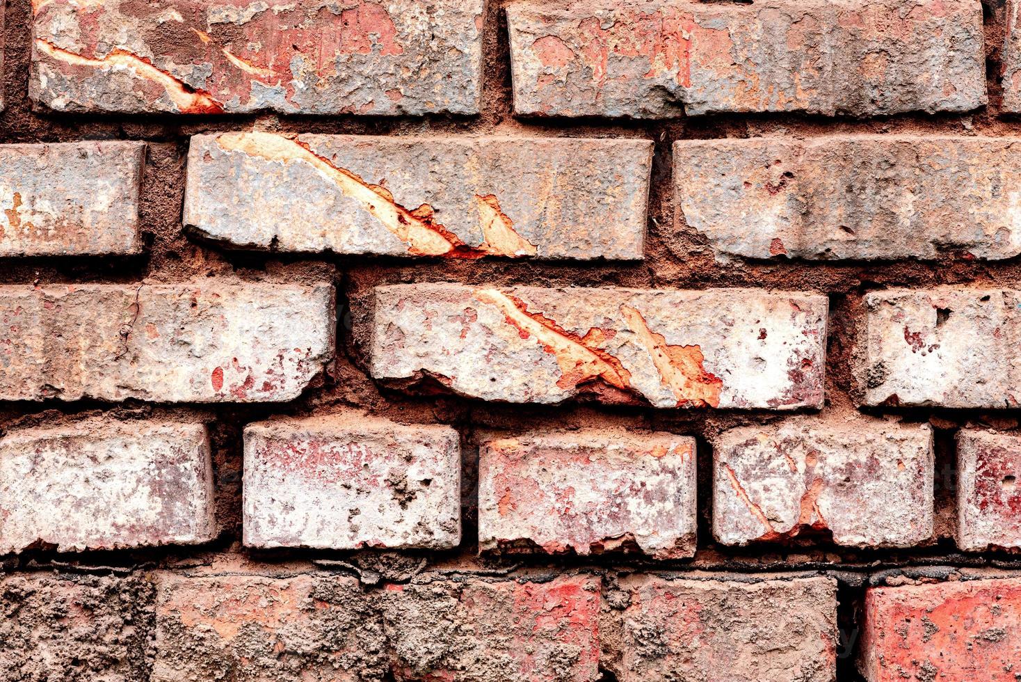 Texture of a brick wall with cracks and scratches which can be used as a background photo