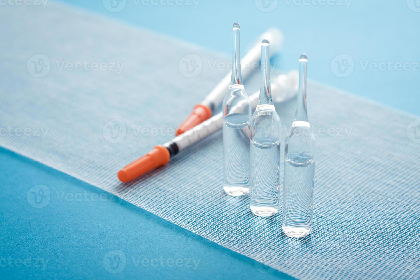 Ampules and syringes on steile bandage surface. Close up image of medical supplies. photo