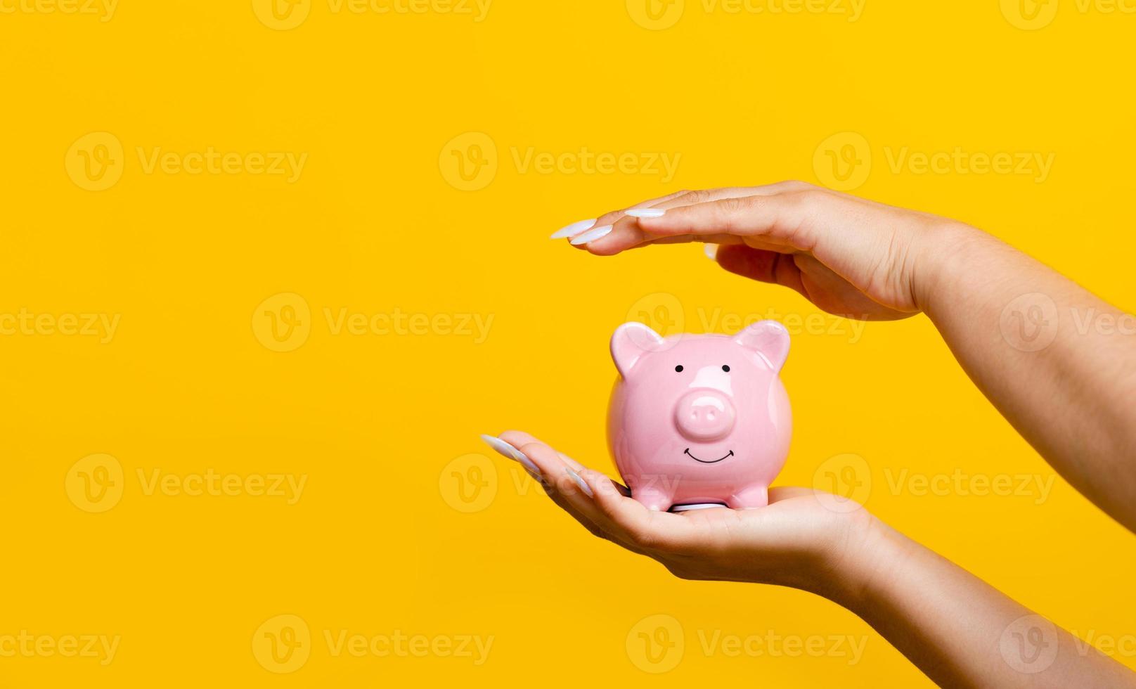 Hand savings and a pink piggy bank with coins inside. enhancing savings The concept of planting a money saving plan and saving expenses increases more income. photo