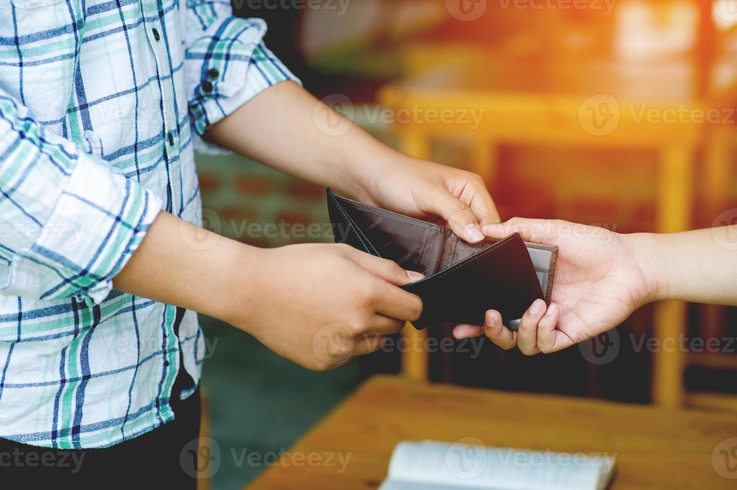 Failure of finances, lack of money, lack of income, unemployment, hands and purse, two men holding the same purse. Shows lack of income, lack of money, working conditions without money. photo