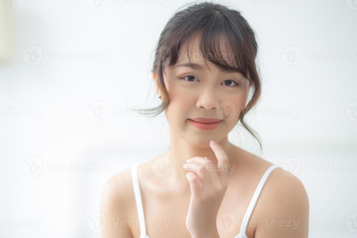 Portrait of beautiful young asian woman smile while wake up healthy and wellness with sunrise at morning in the bedroom, asia girl skin care with happy with fresh, lifestyle and relax concept. photo