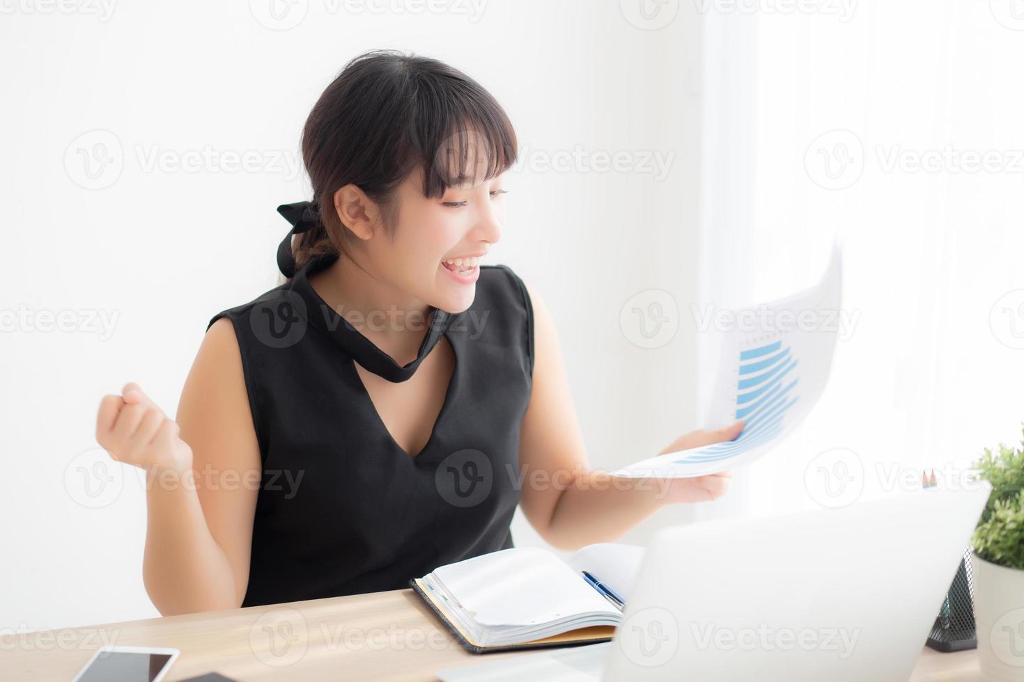 Beautiful young asian woman working laptop computer at office, businesswoman looking graph diagram analysis statistic data with excited and success, girl using notebook, business concept. photo