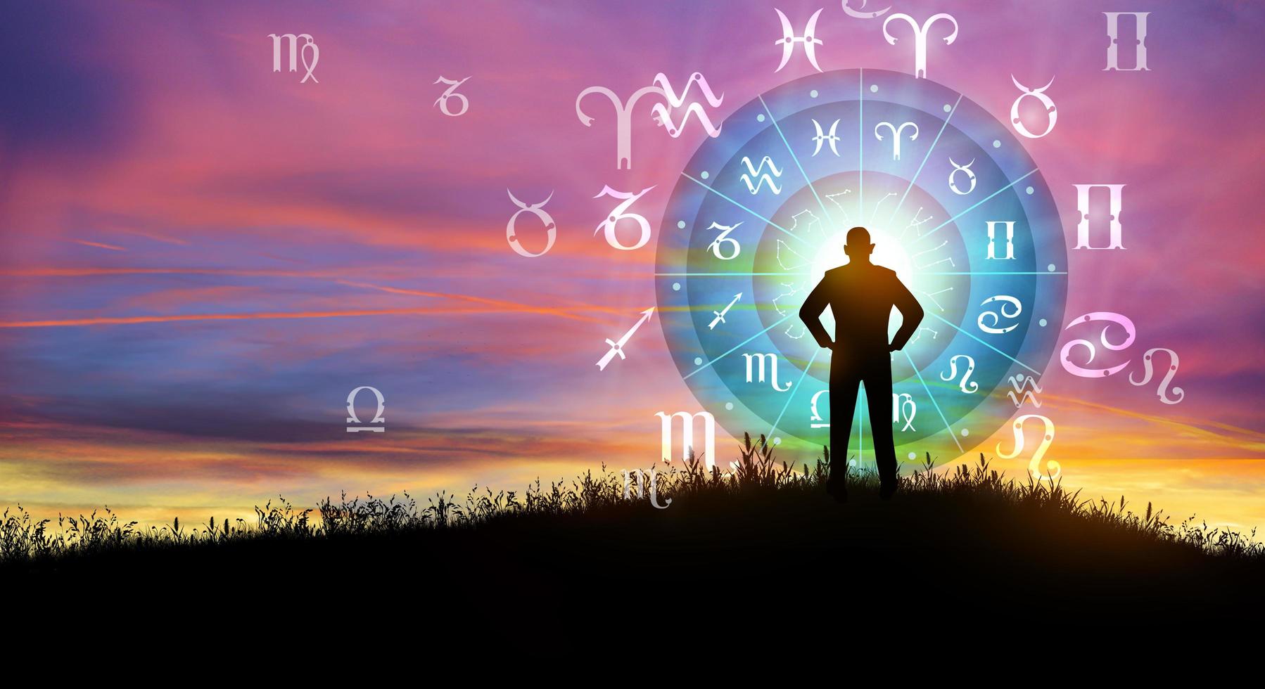 Man silhouette consulting the Sun over the zodiac wheel and Sunrise background. The power of the universe concept. photo