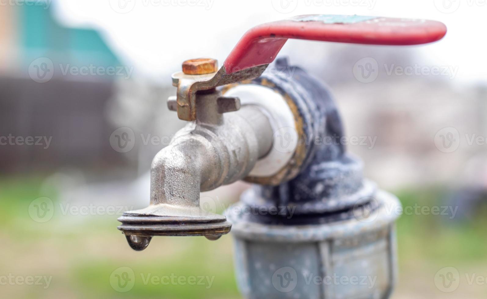 grifo de agua en el fondo de la naturaleza. abrir o cerrar un grifo para ahorrar agua indica un problema de escasez de agua. fuente rústica con luz natural. enfoque selectivo con fondo borroso. foto