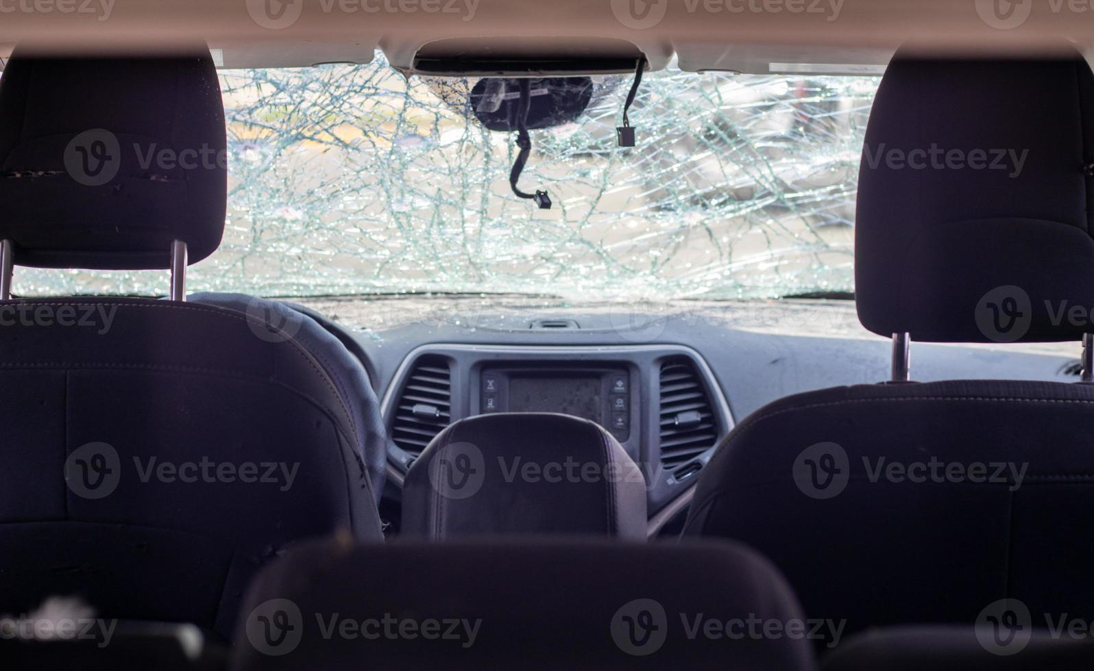 ventana de coche dañada después de un accidente. parabrisas roto como resultado de un accidente, vista interior. detalles del interior de la cabina, vista desde la cabina. movimiento seguro. parabrisas roto. grietas y daños en el vidrio. foto