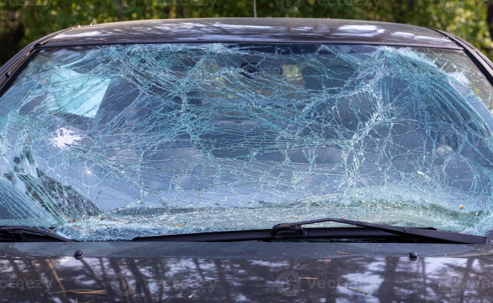 Close-up of a car with a broken windshield after a fatal crash. Consequence of a fatal car accident. Automobile danger. Reckless dangerous driving. Vehicle after an accident with a pedestrian. photo