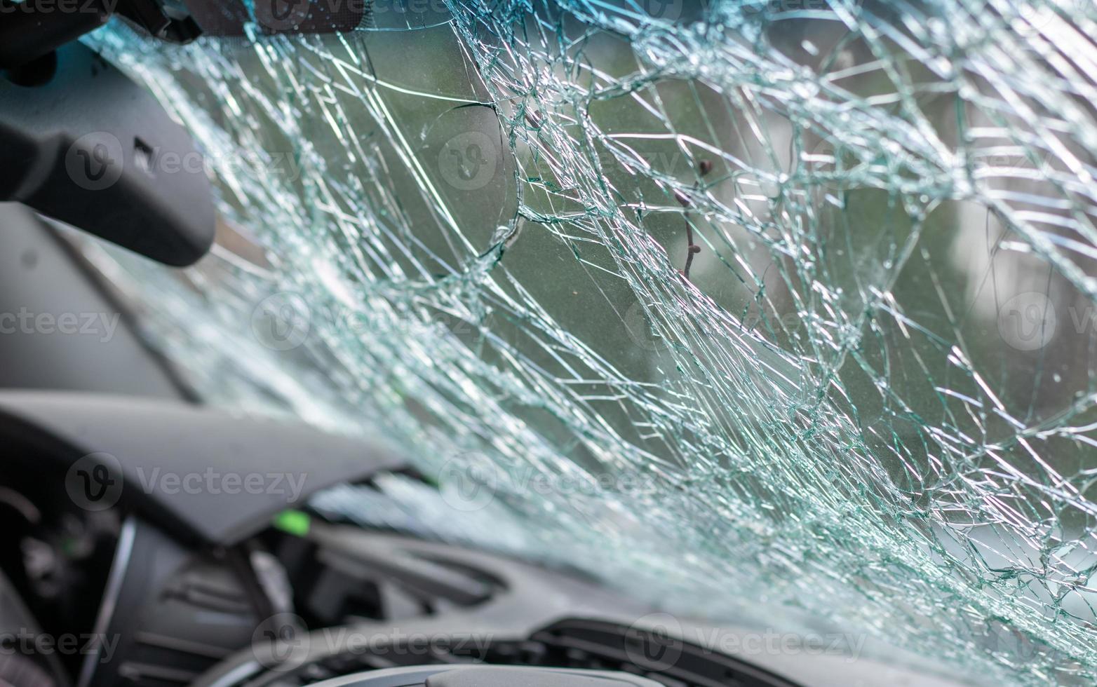 Damaged car window after an accident. Broken windshield as a result of an accident, inside view. Cabin interior details, view from the cab. Safe movement. Broken windshield. Glass crack and damage. photo