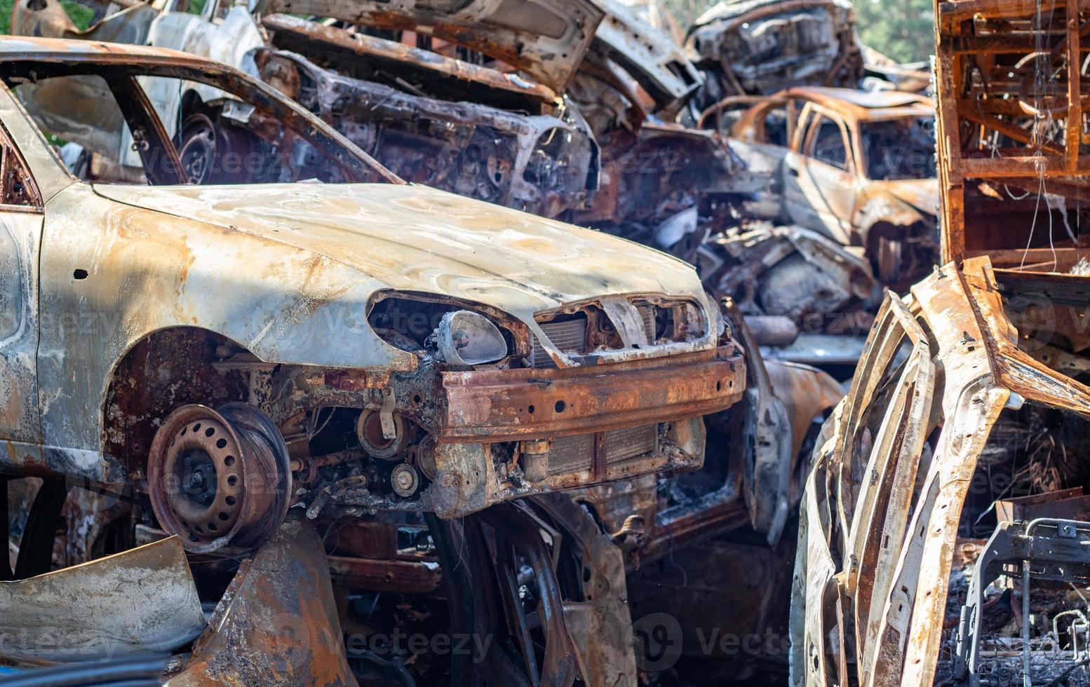 The car burned down completely, even the tires burned out. Burnt out car crash after fire. The bomb shell of the terrorist attack blew up civilians. Disaster zone. Abandoned car on the road. photo