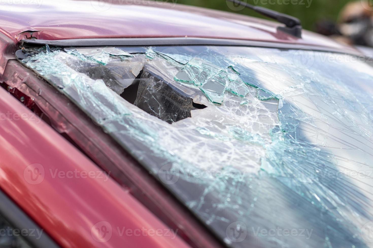 Close-up of a car with a broken windshield after a fatal crash. Consequence of a fatal car accident. Automobile danger. Reckless dangerous driving. Vehicle after an accident with a pedestrian. photo