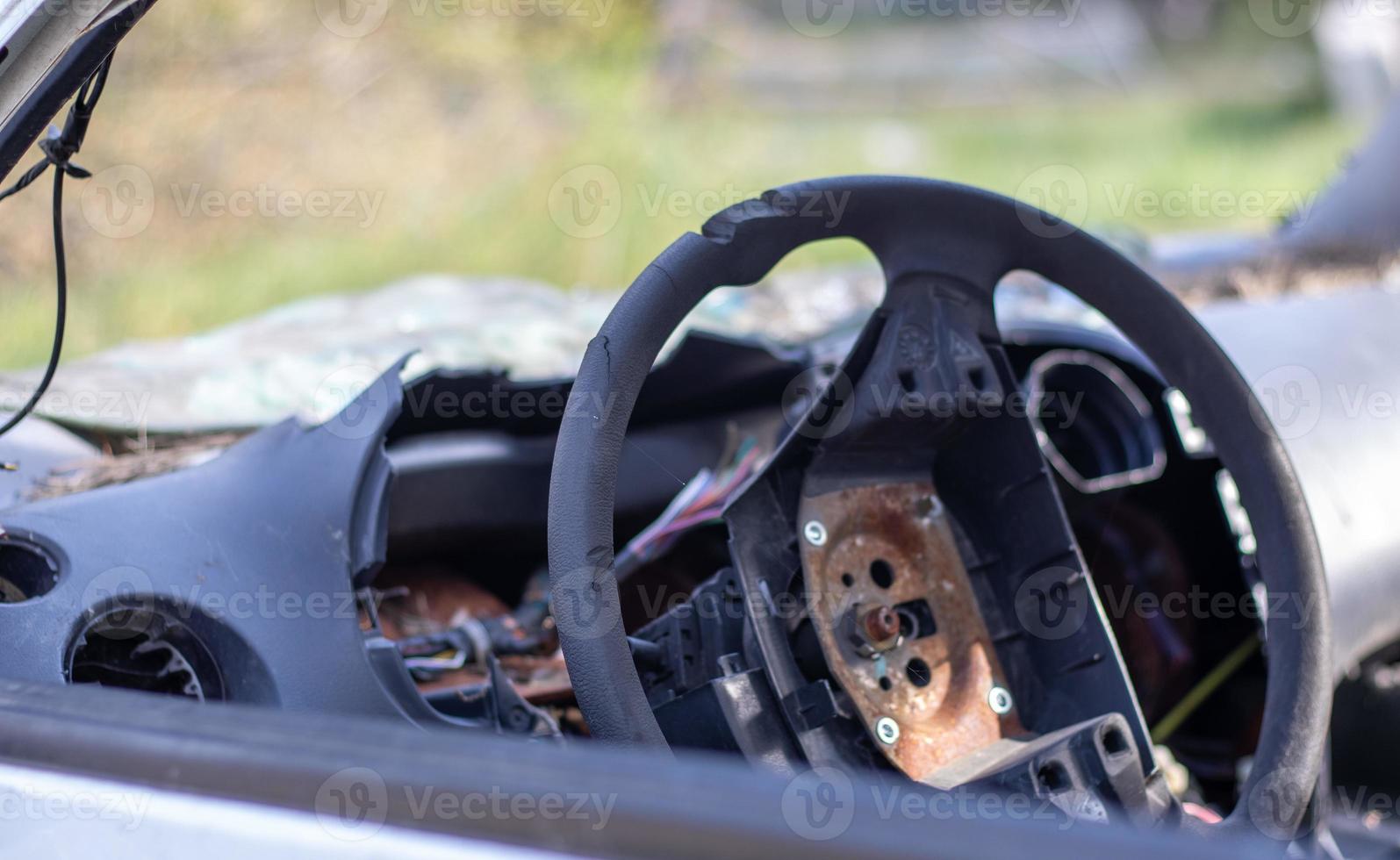 Close-up of the steering wheel of a car after the accident. No driver airbag. The steering wheel of a car after being shot from an airbag close-up. Broken windshield with steering wheel. photo
