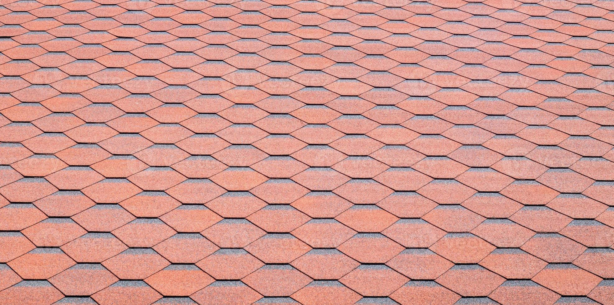 New roof with red shingles. Tiles on the roof of the house. Use to advertise roof fabrication and maintenance. Spotted texture. Affordable roofing. High quality photo with copy space.