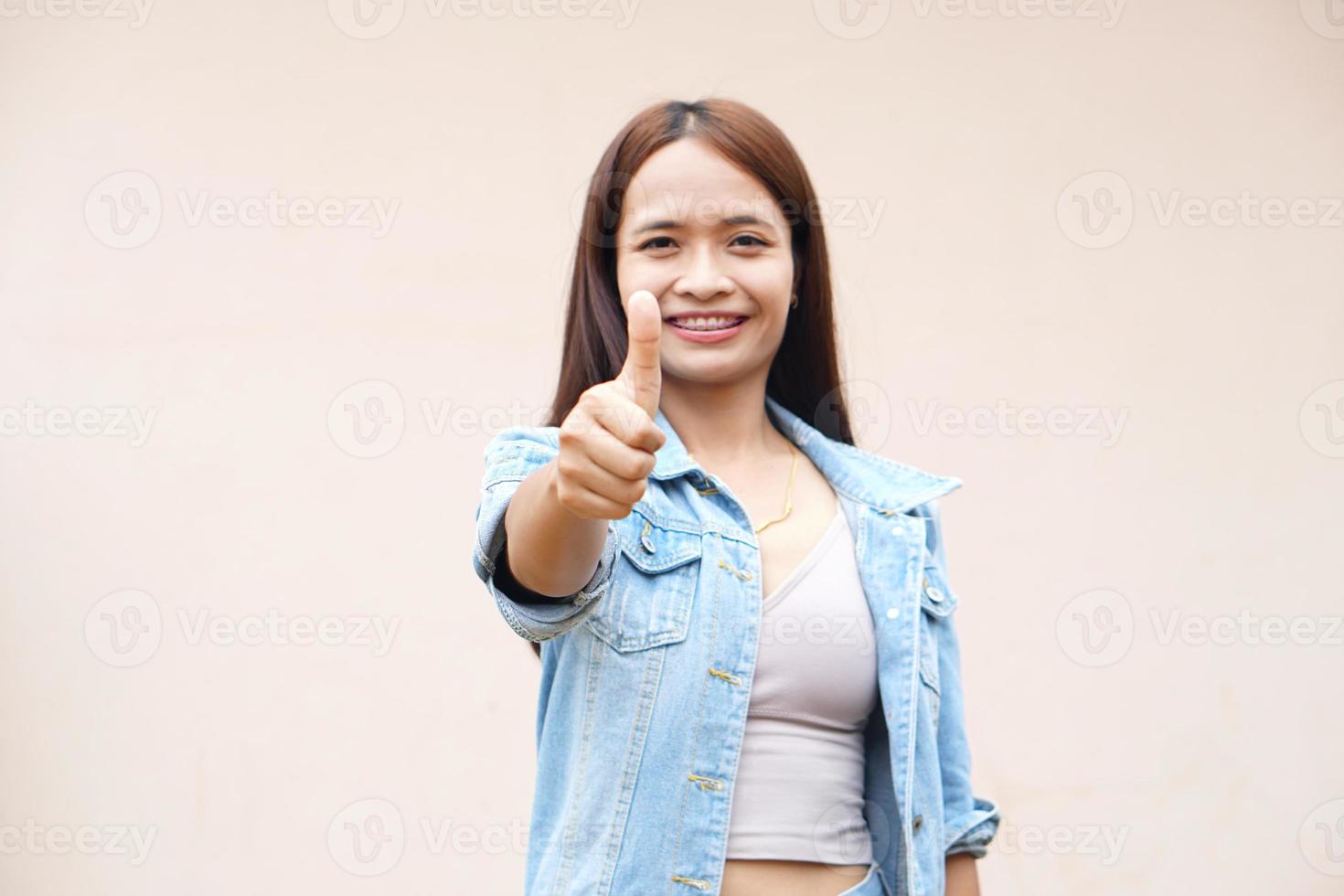 Asian woman smiling happily Raise your hand as a sign of ok. photo