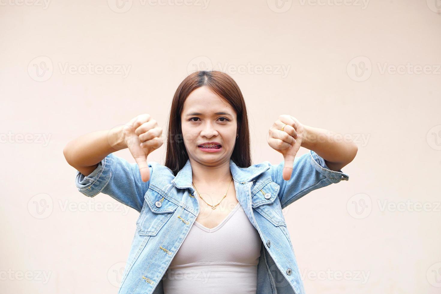 Asian woman raising hand to dislike photo