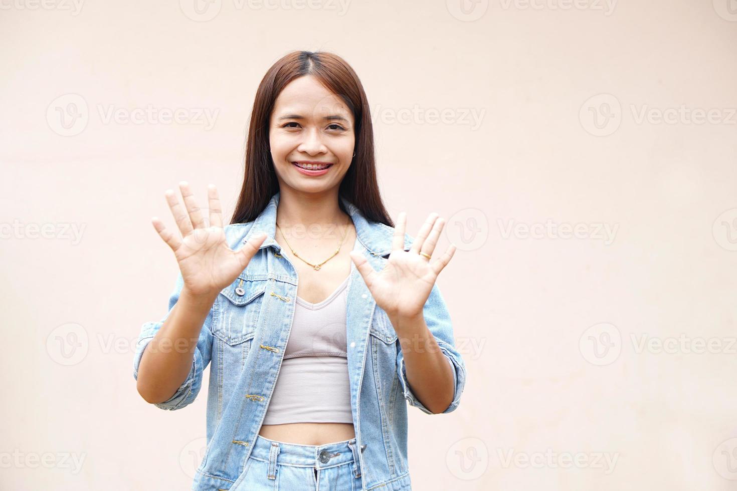 Asian woman raising hand to dislike photo