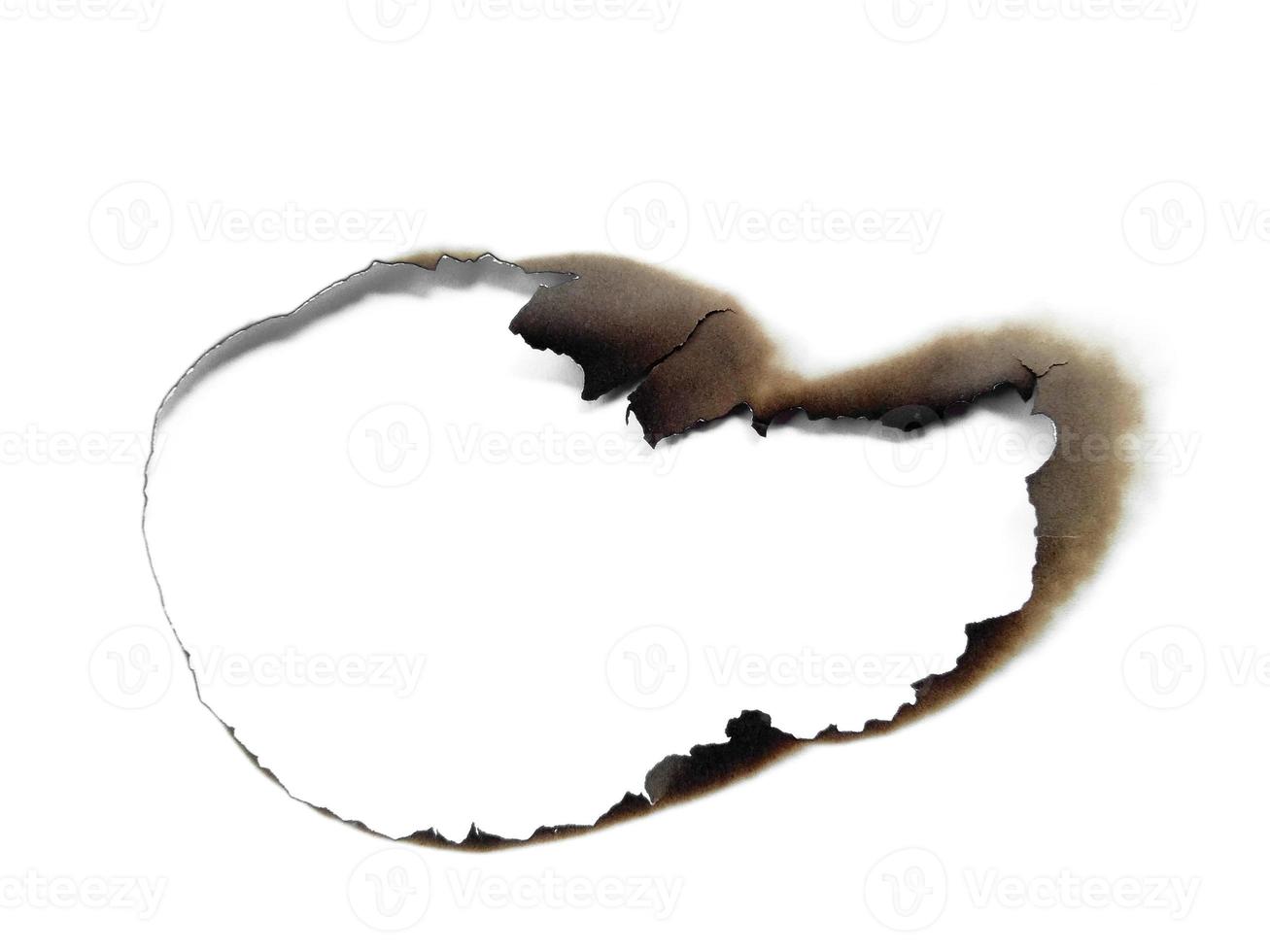 Hole paper with burned edges on white background photo