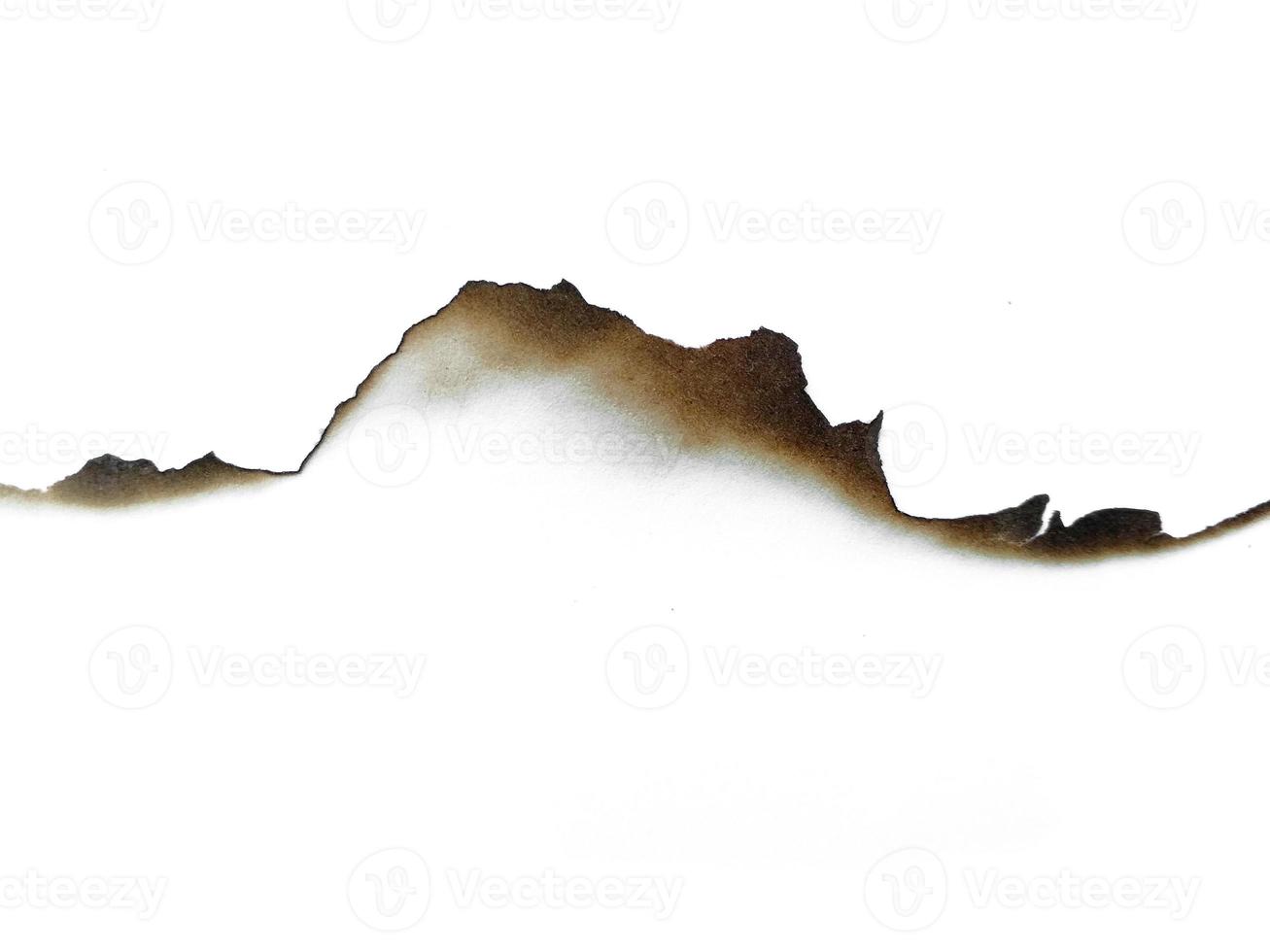 Hole paper with burned edges on white background photo