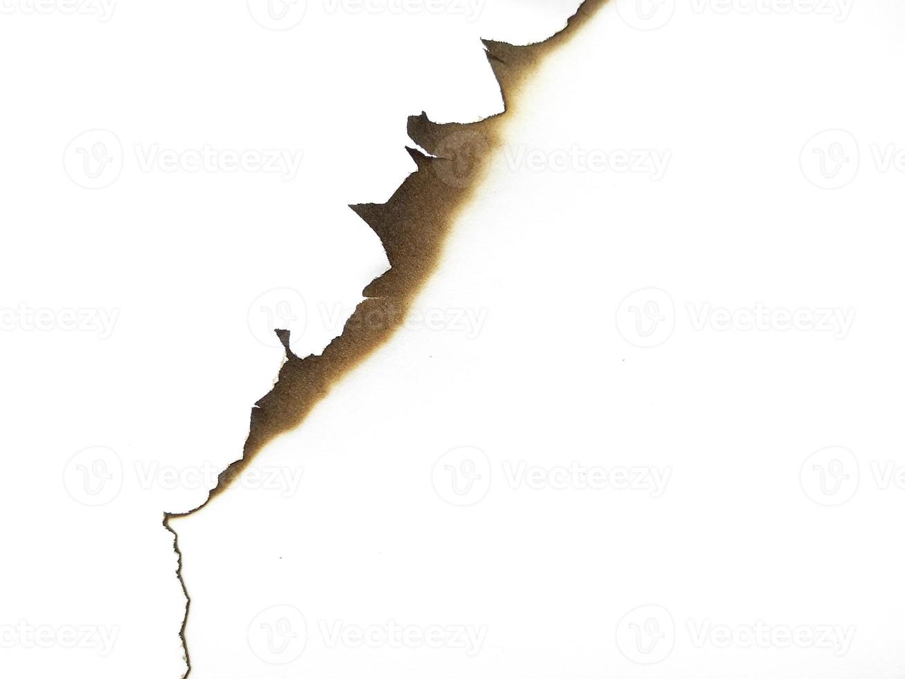 Hole paper with burned edges on white background photo