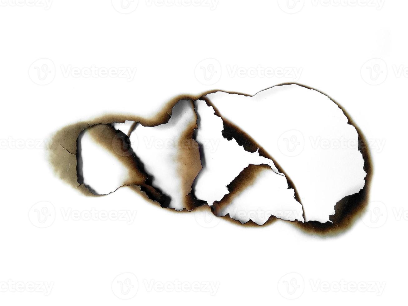 Burnt holes in a piece of paper isolated on white background photo