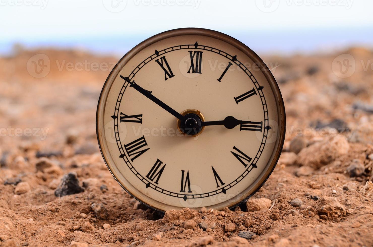 Classic Analog Clock In The Sand photo