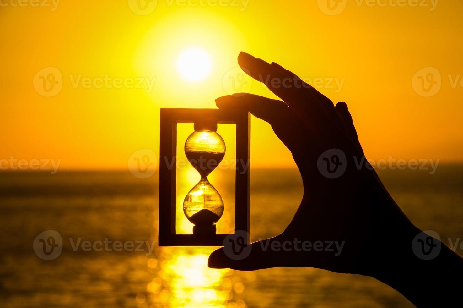 Hand holding hourglass photo