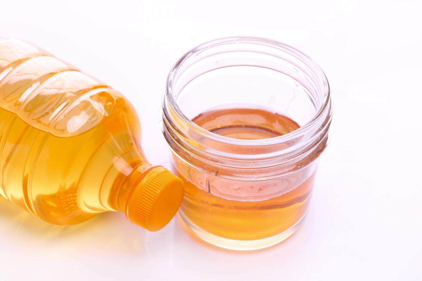 closeup, top view of oil bowl and plastic full cooking oil bottle isolated on white photo