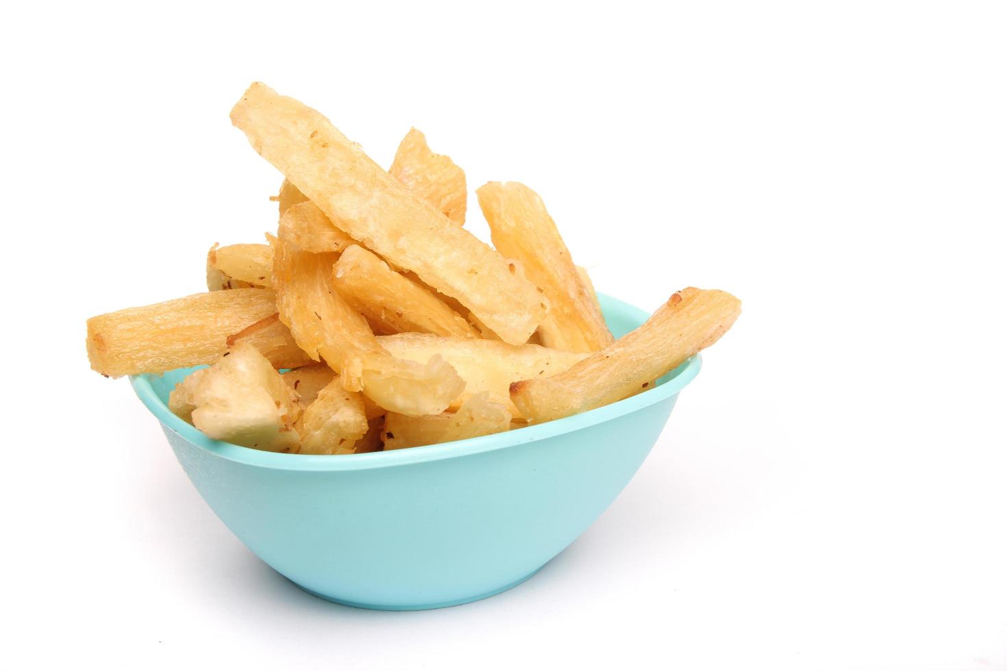 Fried cassava in a blue bowl on a white background, copy space, texture, Indonesian food. photo