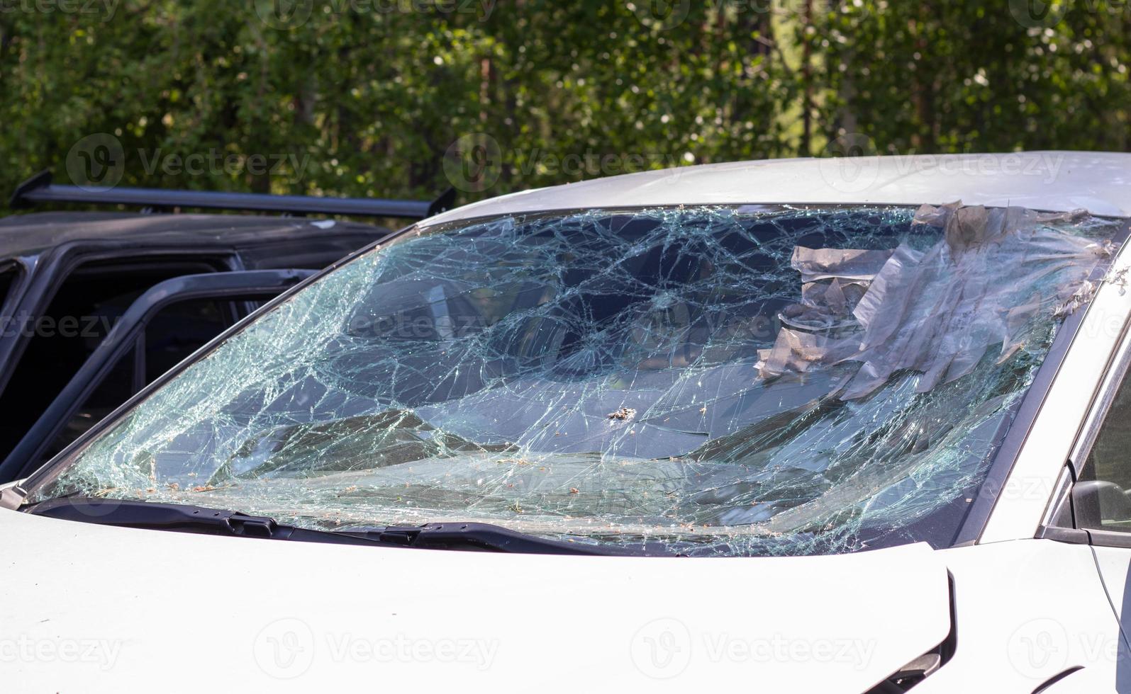 Close-up of a car with a broken windshield after a fatal crash. Consequence of a fatal car accident. Automobile danger. Reckless dangerous driving. Vehicle after an accident with a pedestrian. photo