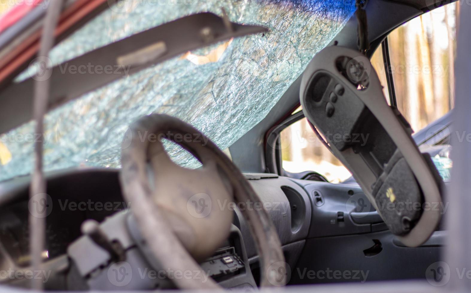 Damaged car window after an accident. Broken windshield as a result of an accident, inside view. Cabin interior details, view from the cab. Safe movement. Broken windshield. Glass crack and damage. photo