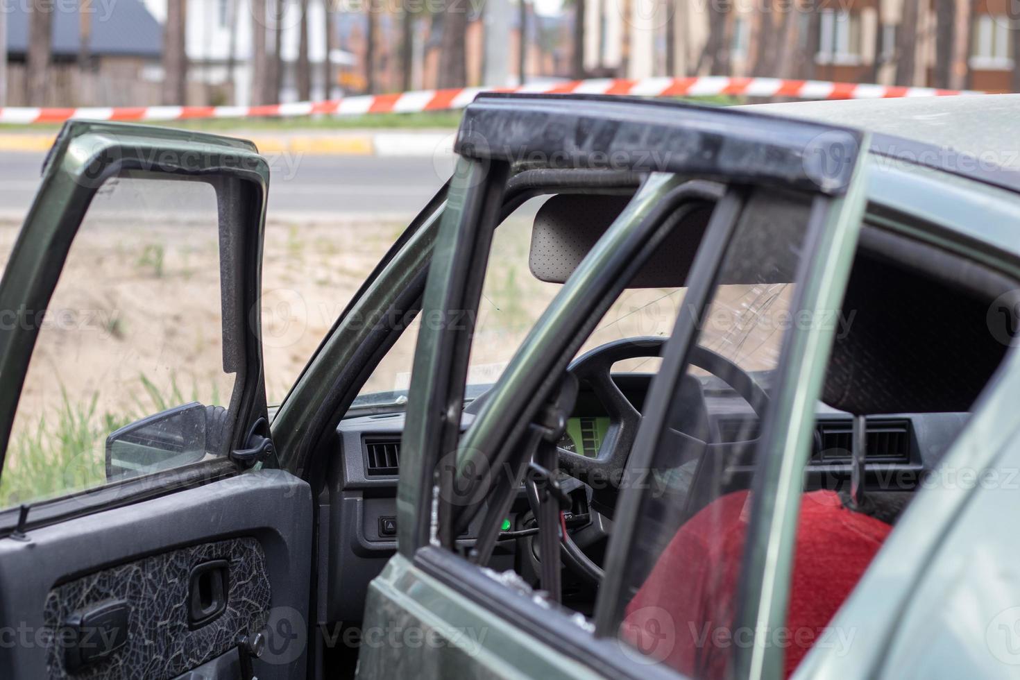 Criminal incident. Breaking into a car parked on the street. Broken side glass and the passenger compartment behind it. A crime committed by a thief, stealing things. Car after an accident. photo